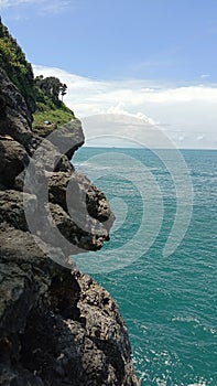 a sturdy rock on the edge of the open sea