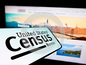 Smartphone with logo of US agency United States Census Bureau (USCB) on screen in front of website.