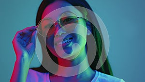 Style and fashion concept. Young positive asian lady in sunglasses smiling to camera, posing in bright neon lights