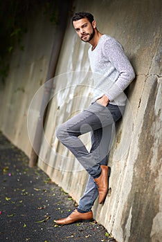 Style isnt just found on the runway. a handsome young man posing against an urban wall.