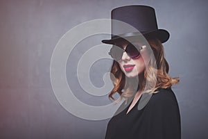 Style and mystique redhead girl in top hat and sunglasses