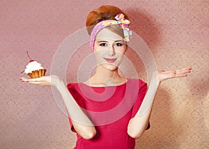 Style redhead girl with cake at pink background.