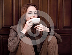 Style redhead girl drinking coffee