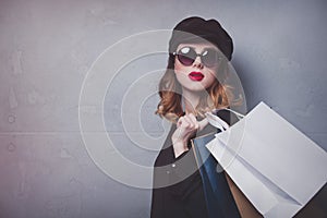 Style redhead girl in hat with shopping bags and sunglasses