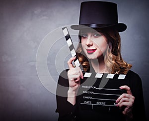 Style redhead girl in top hat with movie clapperboard