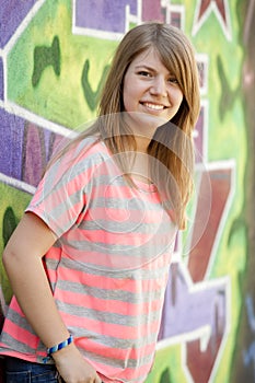 Style teen girl near graffiti wall.