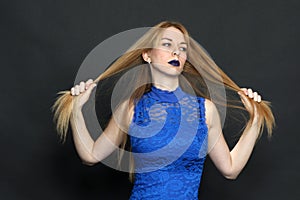Beautiful blonde european girl with blue eyes posing in studio on isolated background. Style, trends, modeling, fashion concept.