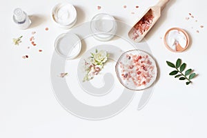 Styled beauty frame, web banner. Skin cream, tonicum bottle, dry flowers, leaves, rose and Himalayan salt. White table photo