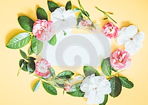 Styled feminine flat lay on pale pastel yello background, top view. Minimal woman`s desktop with blank page mock up, open envelope