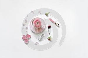 Styled feminine flat lay on white background, top view. Romantic still life - cup of tea, rose petals, perfume, makeup