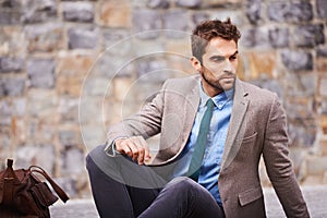 Styled on point. Shot of a handsome and stylish young businessman in an urban setting.