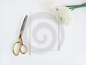 Styled stock photo. Feminine product mockup with bunch of buttercup, Ranunculus and daffodil flowers, blank white frame