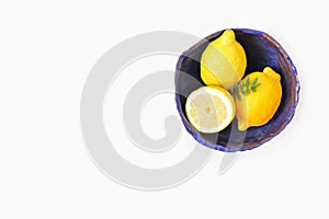 Styled stock photo. Yellow lemon fruit in decorative handmade cobalt blue ceramic bowl. Still life floral composition