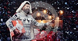 Styling man with a long beard posing on the wooden background. New year gifting concept. Delivery gifts. Gift emotions.