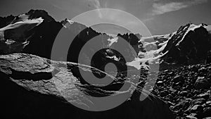 Stylised in an old archived style footage view of mountains with glaciers. 4K bw video with noise and scratches effects.