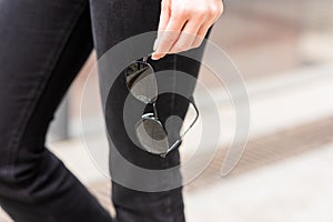 A stylish accessory. Close-up of sunglasses in a woman`s hand