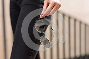 A stylish accessory. Close-up of sunglasses in a woman`s hand