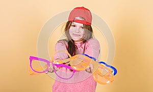 Stylish accessory. Feeling confident with accessories. Girl cute child wear cap or snapback hat hold eyeglasses beige