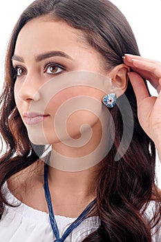 Stylish accessory on woman. Earring on model, necklace on neck.