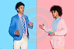 Stylish african american couple with toy teacups with pink and blue