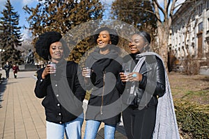 Stylish african american girls drinking coffee on the street