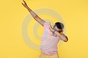 Stylish african american young man dubbing over yellow background.