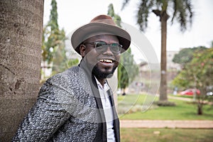 Stylish african businessman looks smilingly around in the park. Outdoor concept photo