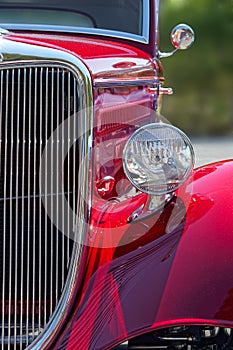 Stylish American hot rod in candy apple red, front view details