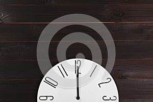 Stylish analog clock hanging on wooden wall, space for text