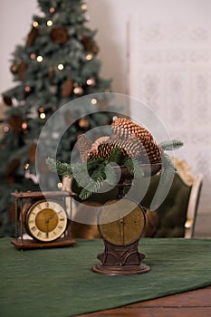 Stylish antique decor with pine cones. A handful of pine cones on an antique bronze scale photo