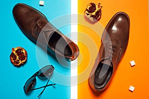 Stylish and arty hipster fashion concept in avant-garde style. Trendy eyewear and shoes on blue and orange background with