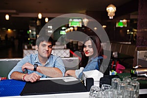 Stylish asian couple wear on jeans sitting on chair at bar in club