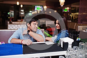 Stylish asian couple wear on jeans sitting on chair at bar in club