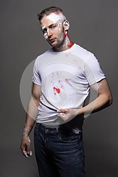 Stylish athletic male artist wearing a white t-shirt stained wit