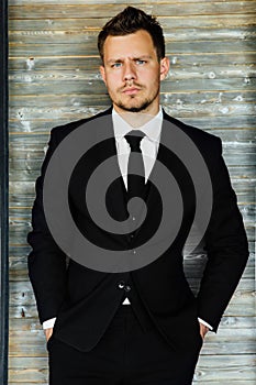 Stylish athletic ofiice man in a business owner costume vest. background of a interior cafe loft.