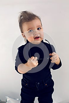 Stylish baby boy in black rocker clothes and sunglasses