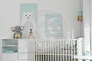 Stylish baby room with crib and cute wall art