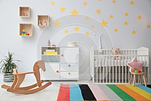 Stylish baby room with crib and toys