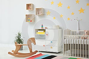 Stylish baby room with crib and toys