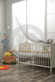 Stylish baby room with crib and toys