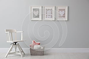 Stylish baby room interior with chair and cute pictures on wall