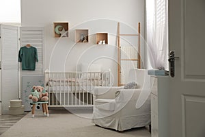 Baby room interior with crib and armchair