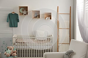 Baby room interior with crib and armchair