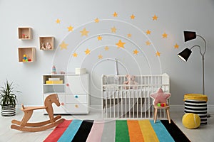 Stylish baby room interior with crib and toys