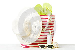 Stylish bag with beach accessories . Summer holiday concept. Top view of beach bag with sunscreen cream with space for