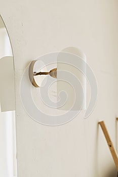 Stylish bathroom design detail. Modern lamp on wall at mirror, modern bathroom interior. Brass and white glass lamp