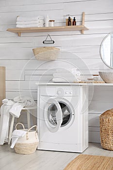 Stylish bathroom interior with modern washing machine