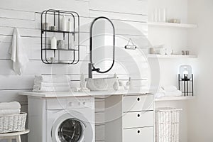 Stylish bathroom interior with modern washing machine