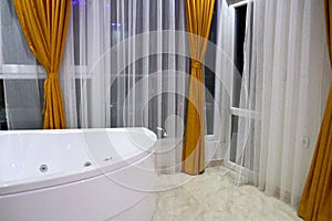 Stylish bathroom with jacuzzi and large french windows