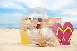 Stylish beach objects and starfishes on sand near sea